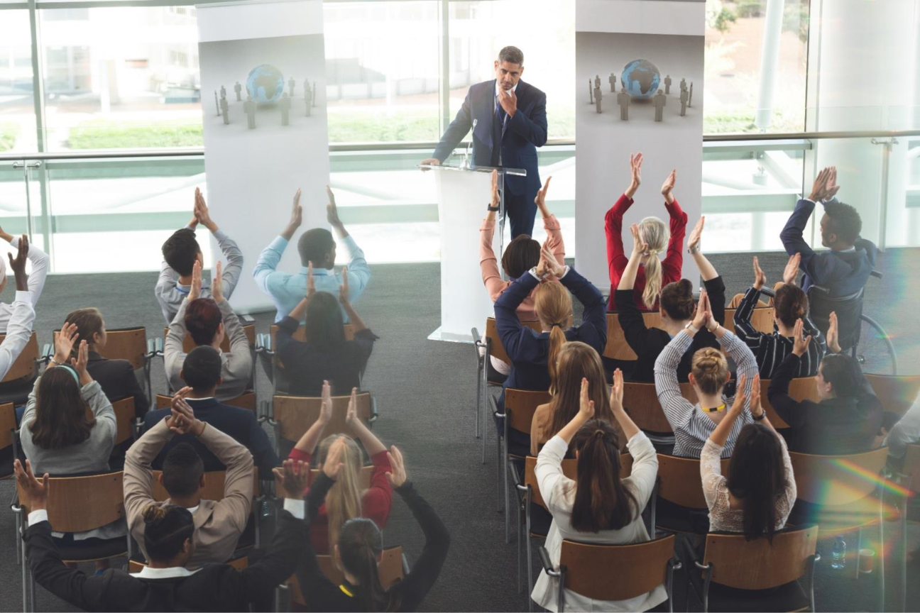 A person giving a presentation to a group of people  AI-generated content may be incorrect.